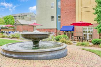 A fountain in the middle of a brick walkway.